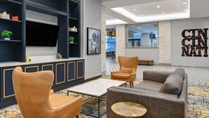 A modern lobby with a seating area, a reception desk, and a large wall with a 'CINCINNATI' sign. - TownePlace Suites by Marriott Cincinnati Downtown (Cincinnati)