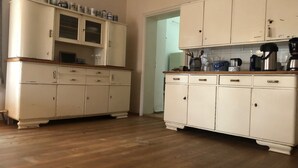 A kitchen with white cabinetry, wooden countertops, and various kitchen appliances.