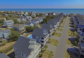 Una zona residencial costera con casas que tienen balcones y una vista despejada del océano.