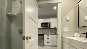 A modern bathroom with a shower, toilet, and sink.