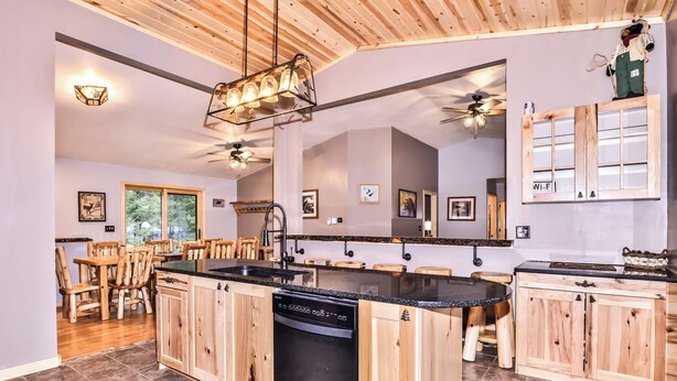 A modern kitchen with wooden cabinets, a central island, and a dishwasher.
