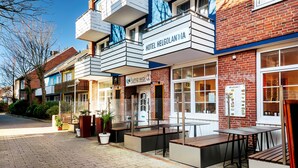 Un hotel con fachada de ladrillo, asientos al aire libre y un letrero que dice 'Hotel Helgolandia'.
