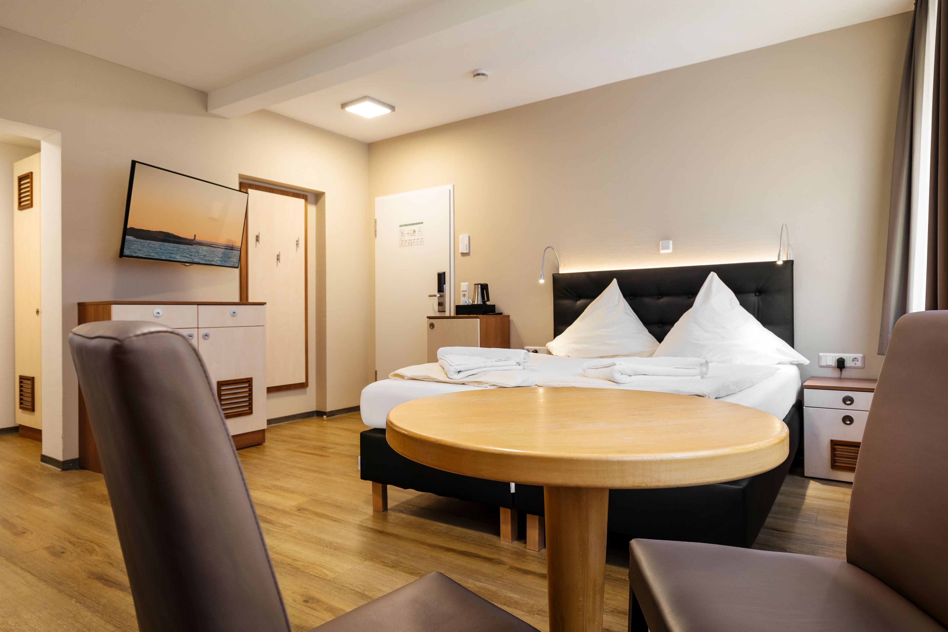 Une chambre d’hôtel avec un lit, une table de chevet, une lampe et un tableau au mur.