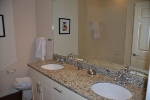 Een badkamer met twee wastafels, een grote spiegel en een toilet.