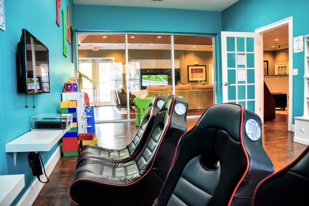 A room with massage chairs, a TV, and a play area with toys.