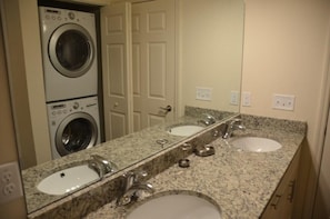 A bathroom with a double sink, a washing machine, and a mirror. - Lucaya Village Resort - 3 Beds and 2 Baths. ID: 57417 (Kissimmee)