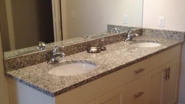 A bathroom with two sinks, a large mirror, and beige cabinetry. - Nov Special at Lucaya 3 Beds 2 Baths Id:57792 (Kissimmee)
