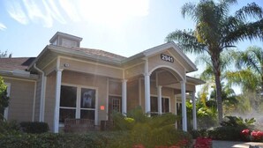 A two-story house with a number 2941 on the front. It has a covered porch with columns and a small bench. - Lucaya 4 Bedrooms 3 Baths Townhome With Central Kitchen (Kissimmee)