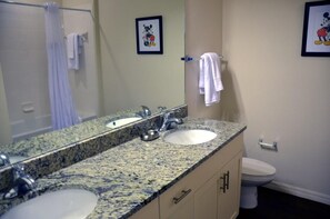 A bathroom with two sinks, a large mirror, and a toilet. - November Promo at Lucaya 3 Beds 2 Baths Id:59007 (Kissimmee)