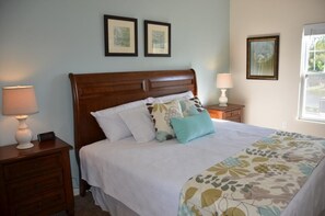 A neatly made bed with a floral bedspread, two bedside tables with lamps, and framed artwork on the wall. - November Promo at Lucaya 3 Beds 2 Baths Id:59007 (Kissimmee)