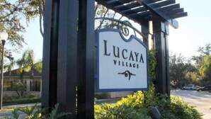 Un letrero de Lucaya Village con una estructura de pérgola.
