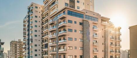 A high-rise building with multiple balconies and a central vertical feature.