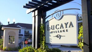 A sign for Lucaya Village with a pergola structure above it.