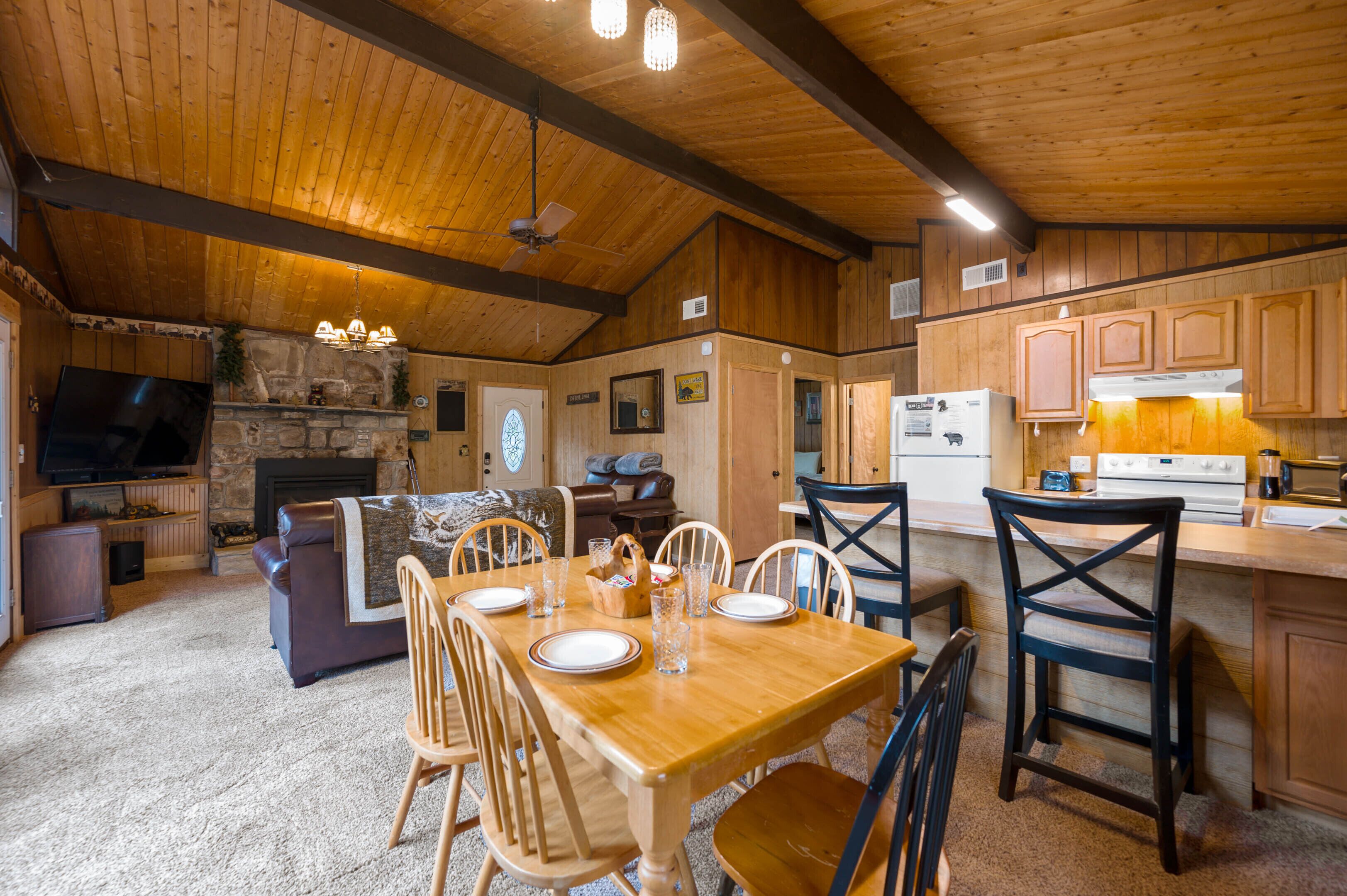 A cozy, wood-paneled interior with a dining area, kitchen, and living room.