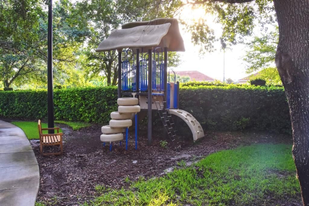 A playground with a slide, climbing structure, and tire swings.