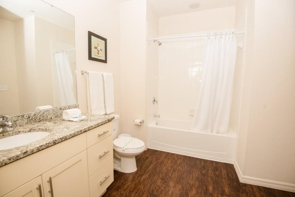 Un baño con lavamanos, inodoro y bañera.