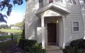 A single-story house with a dark brown front door, white siding, and a small porch area. - December Special Lucaya 4 Bed 3 Bath Id:236904 (Kissimmee)