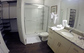A modern bathroom with a glass-enclosed shower, a sink with a granite countertop, and a toilet. - December Special Lucaya 4 Bed 3 Bath Id:236904 (Kissimmee)