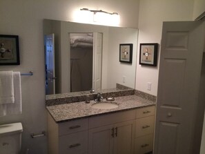 A bathroom with a granite countertop sink, a large mirror, and a framed picture on the wall. - Nov Special at Lucaya 4 Bed 3 Baths Id:275002 (Kissimmee)