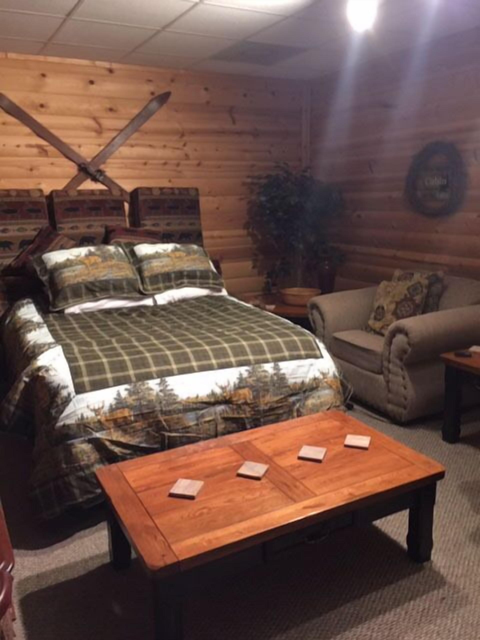 Una habitación acogedora con cama, sofá y una mesa de centro de madera.