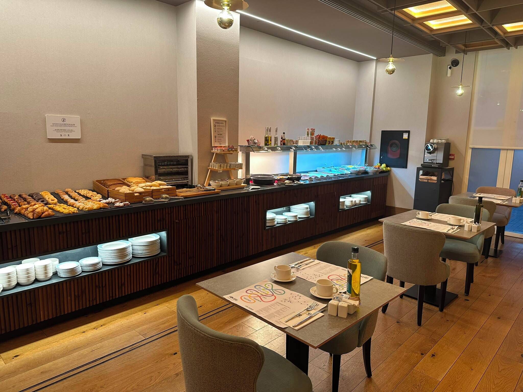 A breakfast buffet with various pastries and a coffee station.
