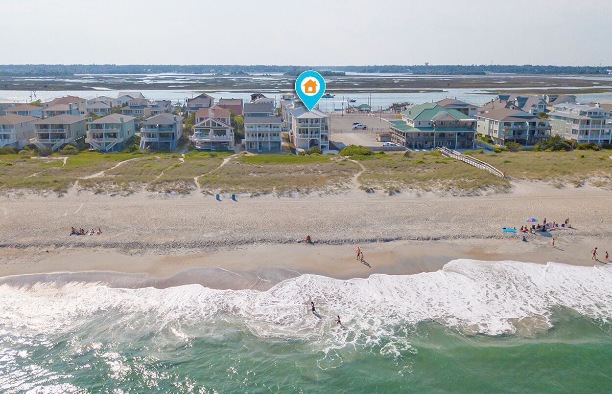 Zona residencial costera con propiedades frente al mar, incluyendo casas y un hotel con vista a la playa.