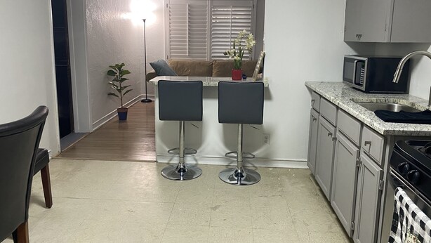 A compact kitchen with a dining area, a microwave, and a sink.