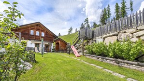 A wooden chalet with a red slide, stone steps, and a stone wall. - Holiday Farm Al Cir 400B (San Martino in Badia)