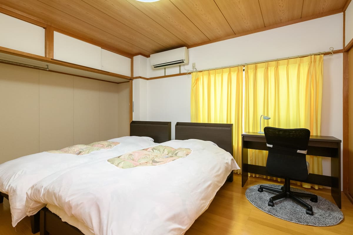 Une chambre avec deux lits, un bureau et une chaise.