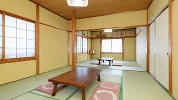 A traditional Japanese room with tatami flooring, a wooden table, and sliding doors.