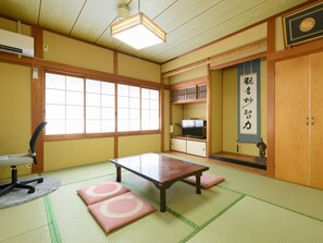 A traditional Japanese room with tatami flooring, a low table, a television, and a sliding door with calligraphy. - Tabist Sakippo Minami-Chita (Minamichita)