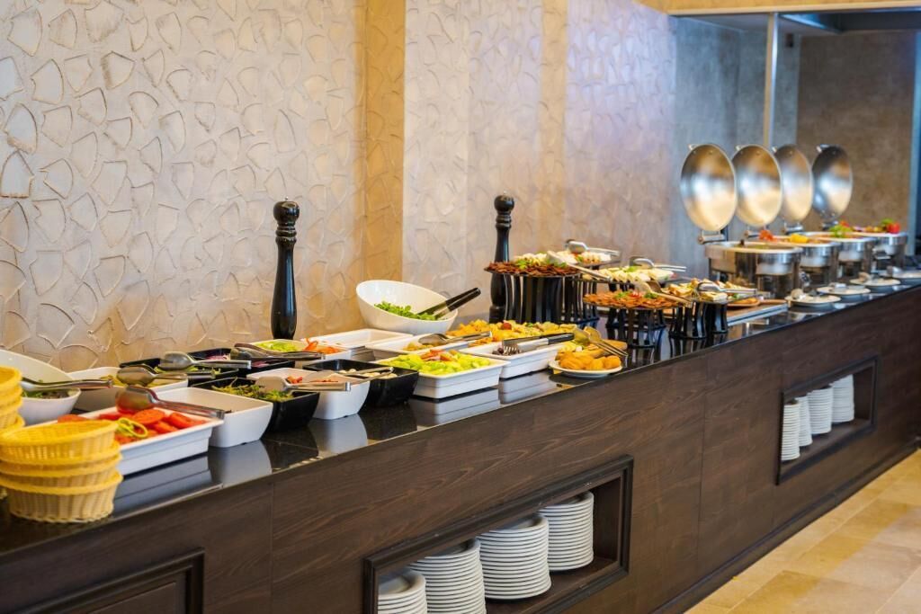 A buffet setup with various food items and serving utensils.