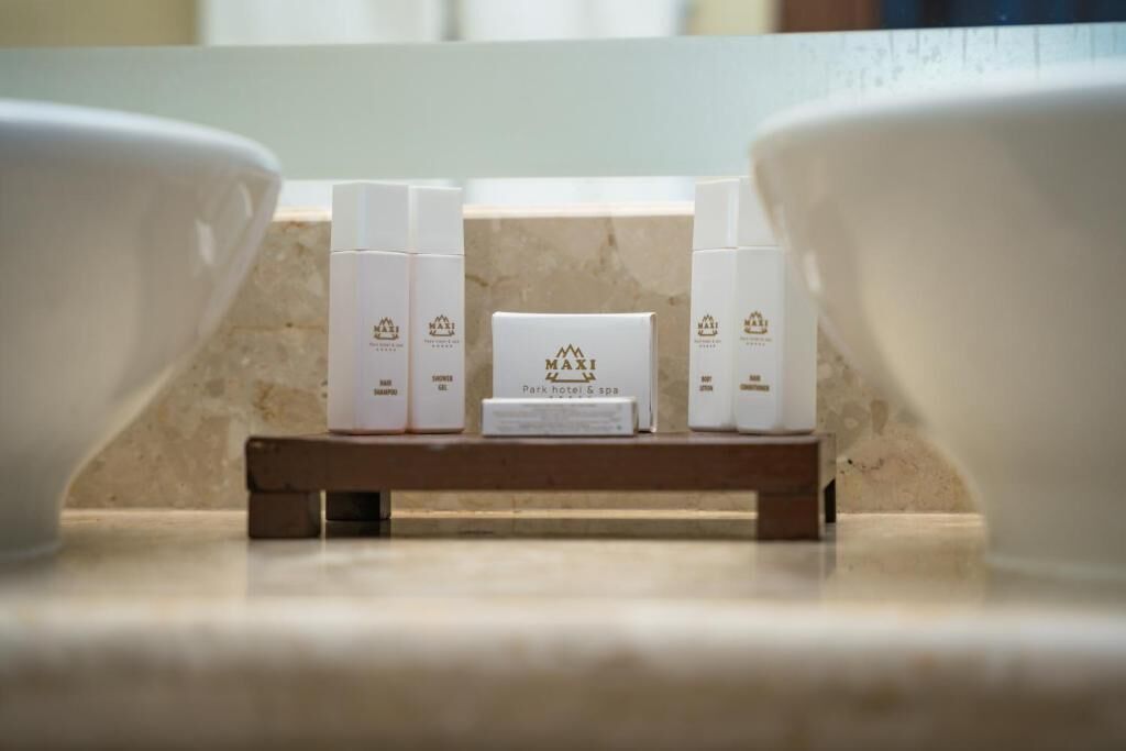 Un juego de artículos de aseo blanco de hotel sobre una bandeja de madera.