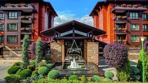 A hotel with a central atrium, stone walls, and a fountain. - Maxi Park Hotel & Spa (Velingrad)