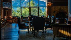 A cozy room with a large window offering a mountain view, a fireplace, and comfortable seating. - Maxi Park Hotel & Spa (Velingrad)