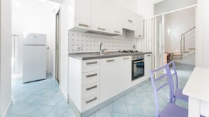 A modern kitchen with white cabinets, a gas stove, and a sink. - Marina Piccola is located in the center of the island, a stone's throw from the beach  (Procida)