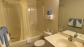 Un baño con bañera, inodoro y lavabo.