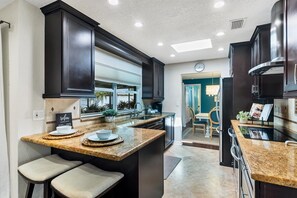 Enjoy cooking in this well-equipped kitchen with a large island, sink, and breakfast bar.