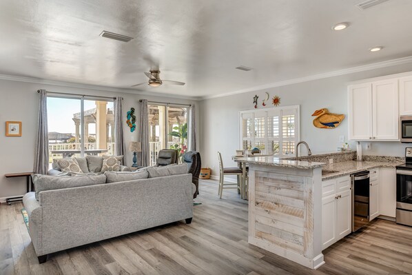 A modern kitchen with white cabinetry, a granite countertop, and stainless steel appliances.