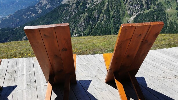 Two wooden Adirondack chairs on a wooden deck with a mountain view. - T4 apartment in the heart of Briançon, 400 m from the Serre-Chevalier slopes (Briançon)