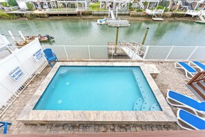 A pool area with a lifeguard station, lounge chairs, and a view of the water. - Flip Flop Paradise - Unique 4 Bedroom Channel Home in Cherry Grove - Walk to Beach (North Myrtle Beach)