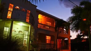 A two-story building with balconies and a green door, surrounded by palm trees. - Relaxing, Amazing beach, pool, Cheap cars, quiet area, surfers paradise 2 (Atlantic Shores)