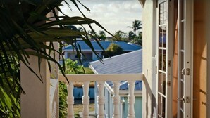 A balcony with a white balustrade overlooking a residential area with houses and palm trees. - Relaxing, Amazing beach, pool, Cheap cars, quiet area, surfers paradise 2 (Atlantic Shores)