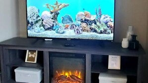 A television on a dark wooden stand with a "welcome" sign above it.