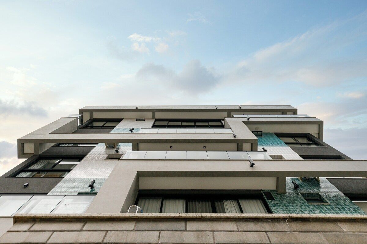 A modern building with a geometric facade, multiple levels, and large windows.