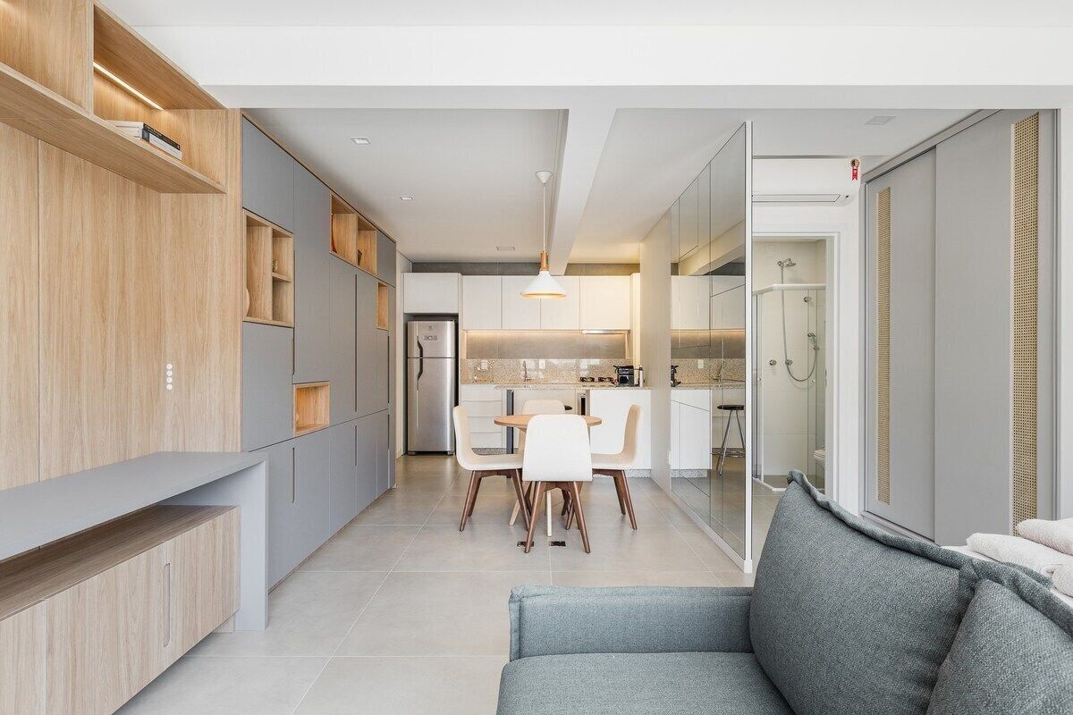 Una cocina moderna con comedor, sofá y puerta corredera de vidrio que da a un baño.