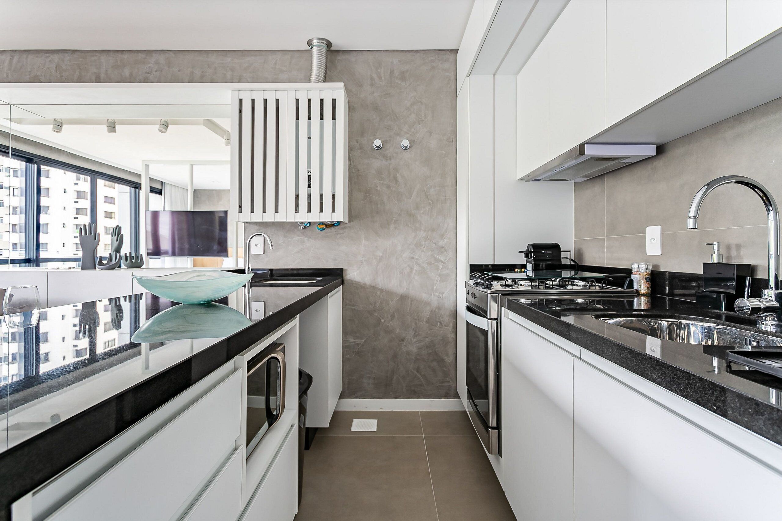 A modern kitchen with a large island, stainless steel appliances, and a view of the city.