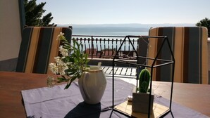 A table with a vase of flowers, a cactus, and a metal stand. - Apartments Tamara (ST)- Two Bedroom Apartment with Balcony (Lokva Rogoznica)