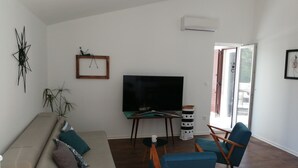 A living room with a sofa, two blue chairs, a TV, and a small table. - Apartments Tamara (ST)- Two Bedroom Apartment with Balcony (Lokva Rogoznica)