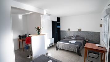 Una habitación de hotel moderna con cama, escritorio, silla y una mesita.